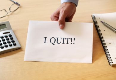 Man's hand holding 'I quit' resignation note Man's hand holding 'I quit' resignation note