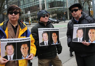 Protesters hold signs calling for the release of Canadian citizens Michael Spavor and Michael Kovrig outside British Columbia Superior Court in March 2019