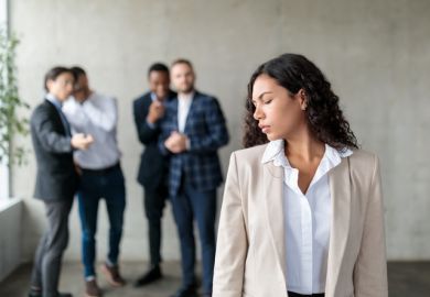 A group of men whisper behind a woman's back