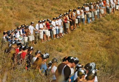 Miners standing in a line in a field