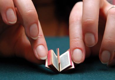 Person reading miniature book Person reading miniature book