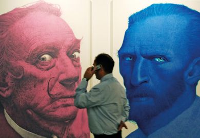 A man phones in front of portraits of the Salvador Dali (L) and Vincent Van Gogh (R) 