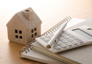 Model of house with calculator and notepads