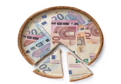 A pie made of Euro notes with cut slices at the bottom