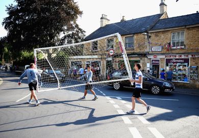 Players carry the goal posts away from the river following a football match, Bourton-on-the-Water, England. To illustrate a late surge in UK student visa refusals.