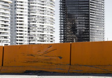 New modern inner city apartments against grungy orange road barrier.