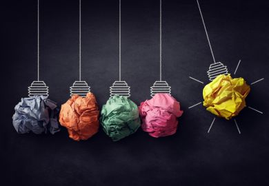 A Newton's cradle with crumpled paper lightbulbs, one of which is lit, symbolising ideas for efficiency