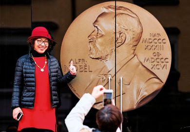 An Asian woman poses for a picture at the entrance of the Alfred Nobel Museum in Stockholm, Sweden, 2019.  An Asian woman poses for a picture at the entrance of the Alfred Nobel Museum in Stockholm, Sweden, 2019.