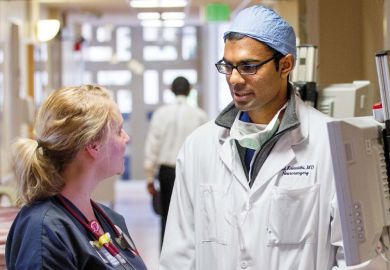 Nurse speaks with doctor. Stanford University Hospital and Clinics
