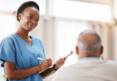 A nurse with a clipboard taking a patient’s details