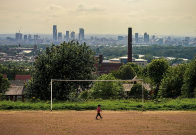 A general view of an old cotton mill in Oldham with the city of Manchester on the horizon, 2020