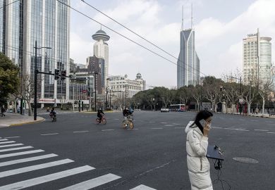 Woman in mask carrying laptop