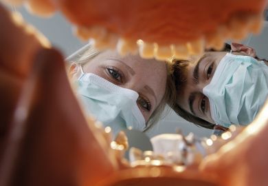 View from within a set of dentures onto two future dentists during their dental training View from within a set of dentures onto two future dentists during their dental training