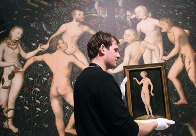 An employee of the Städel Museum gives Venus by Lucas Cranach the Elder the white-glove treatment