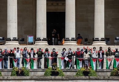 Students from UCL hold up hands painted red during a pro-Palestinian rally, 2024