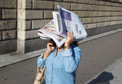 Woman on mobile phone with head covered by newspaper, illustrating review of Forgotten Wives: How Women Get Written Out of History By Ann Oakley