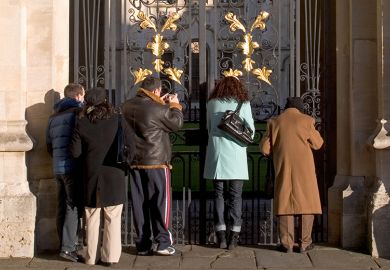 People look though gate to All Souls College, Oxford, to illustrate the university is to review admissions policies and scholarships as part of an institution-wide focus on postgraduate participation