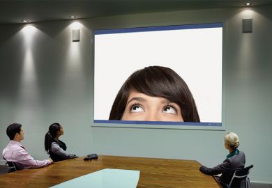 People taking part in Skype call in conference room