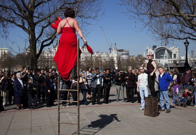 A busker performs balancing on a ladder for a crowd along the Southbank. London. To illustrate that pay awards offered to staff at universities that do not participate in collective bargaining have risen above the national offer. A busker performs balancing on a ladder for a crowd along the Southbank. London. To illustrate that pay awards offered to staff at universities that do not participate in collective bargaining have risen above the national offer.