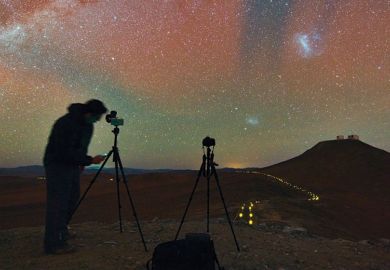 Person taking photographs of and recording night sky