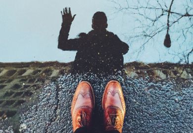 Person waving at reflection in street puddle