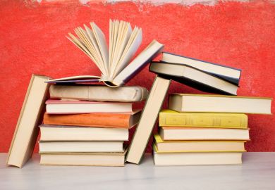 Pile of books against red wall