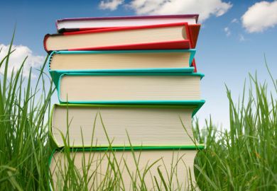 Pile of books on grass, summertime