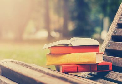 Pile of books on park bench Pile of books on park bench