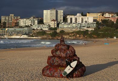 A surfer interacts with a sculpture titled 'Plastic pile of sh!t, 2023' at Bondi Beach on 5 June, 2023 in Sydney, Australia. To illustrate a ‘bullshit index’ for policy documents developed by an Australian educational researcher.