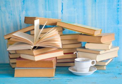 Piles of books with cup of tea