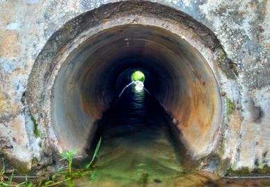 A narrowing pipe with water flowing through it A narrowing pipe with water flowing through it