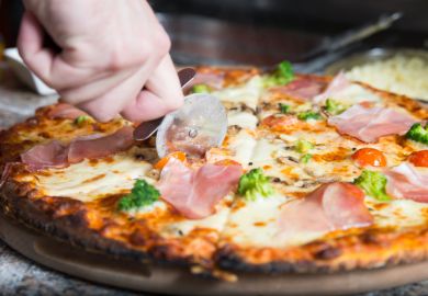A pizza being sliced