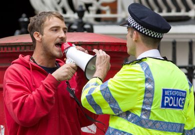 A police officer remonstrates with a protester on a street during a demonstration in London. 18.08.2014