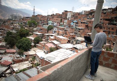 Boy with laptop on balcony