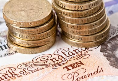 Pound coins stacked on ten pound note