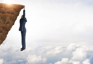 A man hangs from a precipice