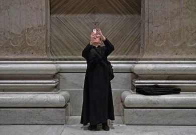 Priest taking photo with smartphone in church