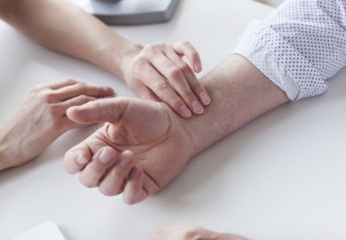 A doctor taking someone's pulse