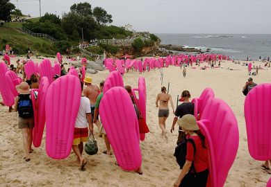 Swimmers with pink airbeds queue on Coogee beach in Sydney, Australia. To illustrate a landmark court decision that could force Australian universities to constantly increase their casual staff numbers to cover teaching needs.