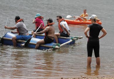 People paddling on a makeshift raft