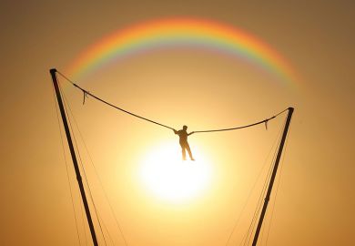 person bouncing in front of rainbow