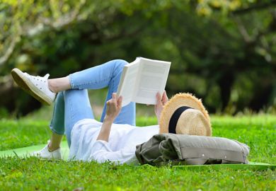 A woman lying on her back reading A woman lying on her back reading