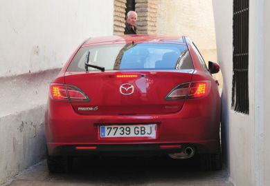 Red car stuck in alleyway, Córdoba, Spain