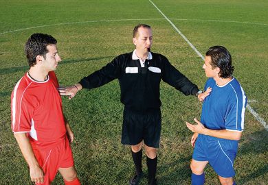 Referee between two footballers