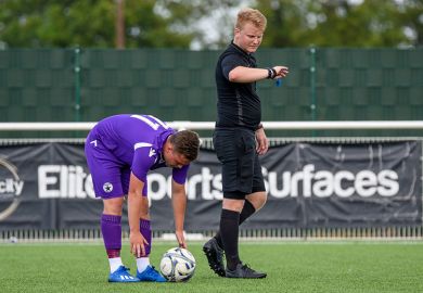 A referee looks at his watch before the kick off of a football match, illustrating that dozens of higher education institutions are to publish their accounts late.