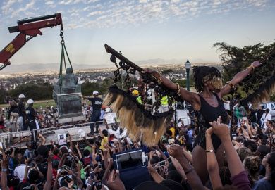 Students cheer as the Cecil Rhodes statue is being removed from the University of Cape Town on April 9, 2015
