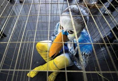 Sad young woman dressed as bird in cage Sad young woman dressed as bird in cage
