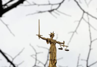 A statue of the scales of justice stands above the Old Bailey, London. To illustrate 