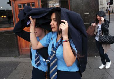 Schoolgirls shelter heads from rain, Liverpool Schoolgirls shelter heads from rain, Liverpool