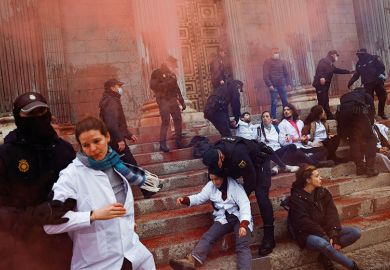 Police officers try to prevent Scientist Rebellion activists from throwing red paint at the exterior of the Spanish Parliament to protest climate change, in Madrid, Spain, April 6, 2022